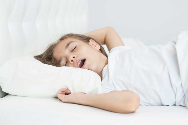 child suffering from sleep apnea, snoring with an open mouth