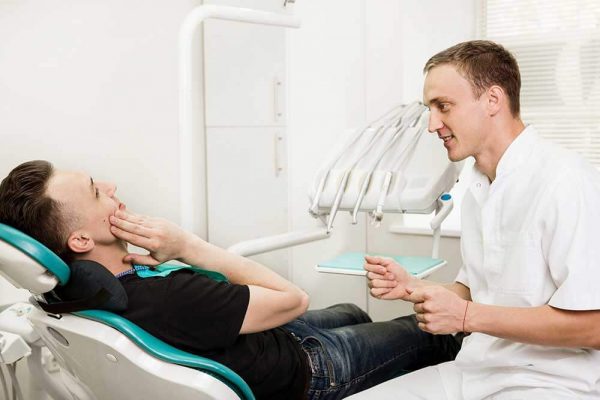 dentist treating patient on a dental chair for tooth pain