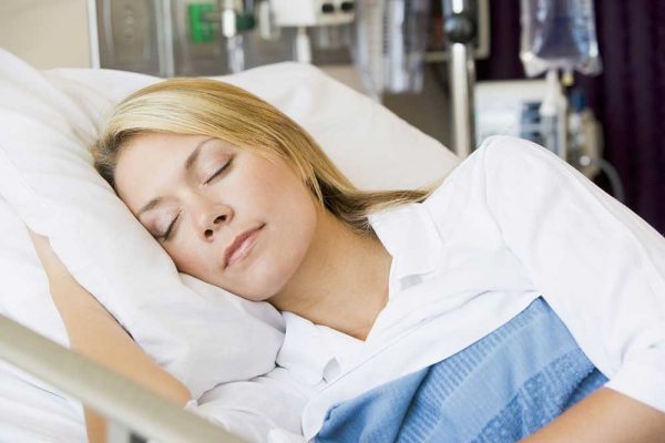 Woman asleep on hospital bed